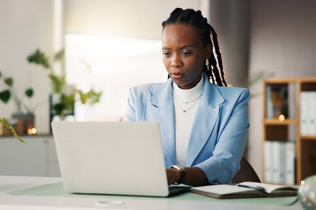 An office employee proofreading a work task before publication from her laptop.