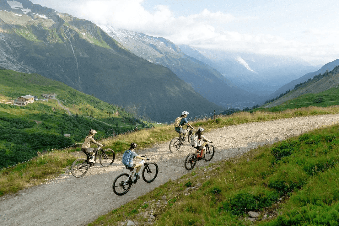 A group of e-mountain bikers riding through glacial mountains.