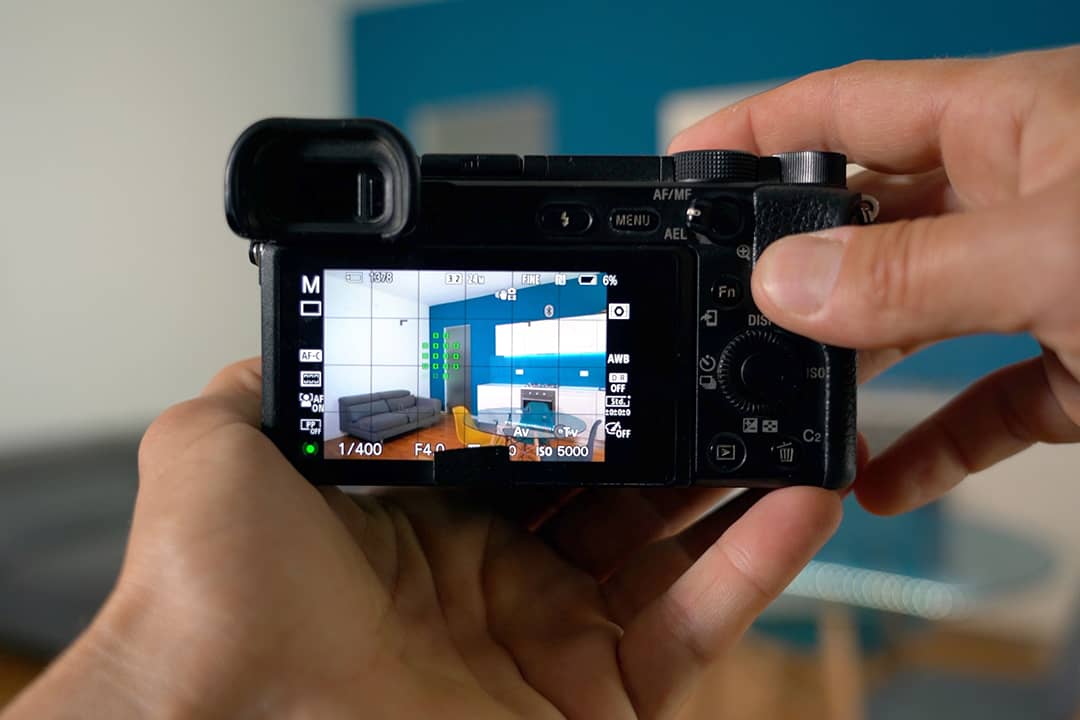 Person professionally taking a photograph of a home's interior.
