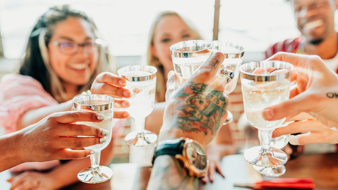 A group of friends toasting their drinks together during a celebration.