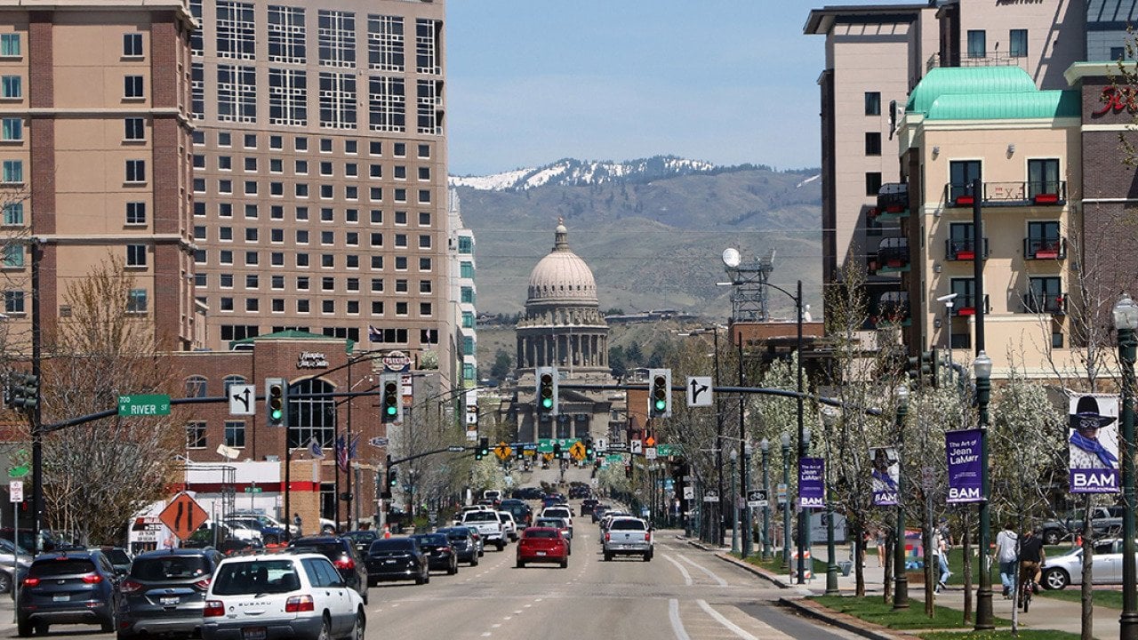 A view of the Idaho state capitol building downtown with overlooking mountains at the back.