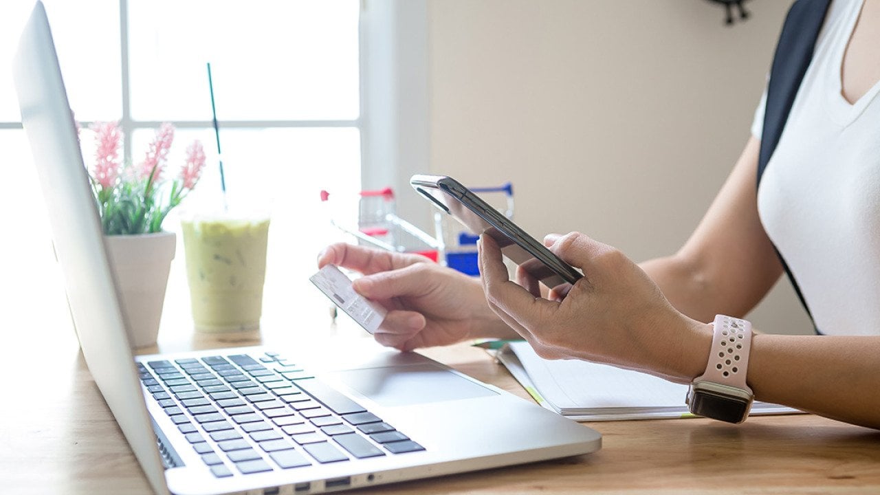 A person checking her credit card's details for a digital transaction from online shopping.