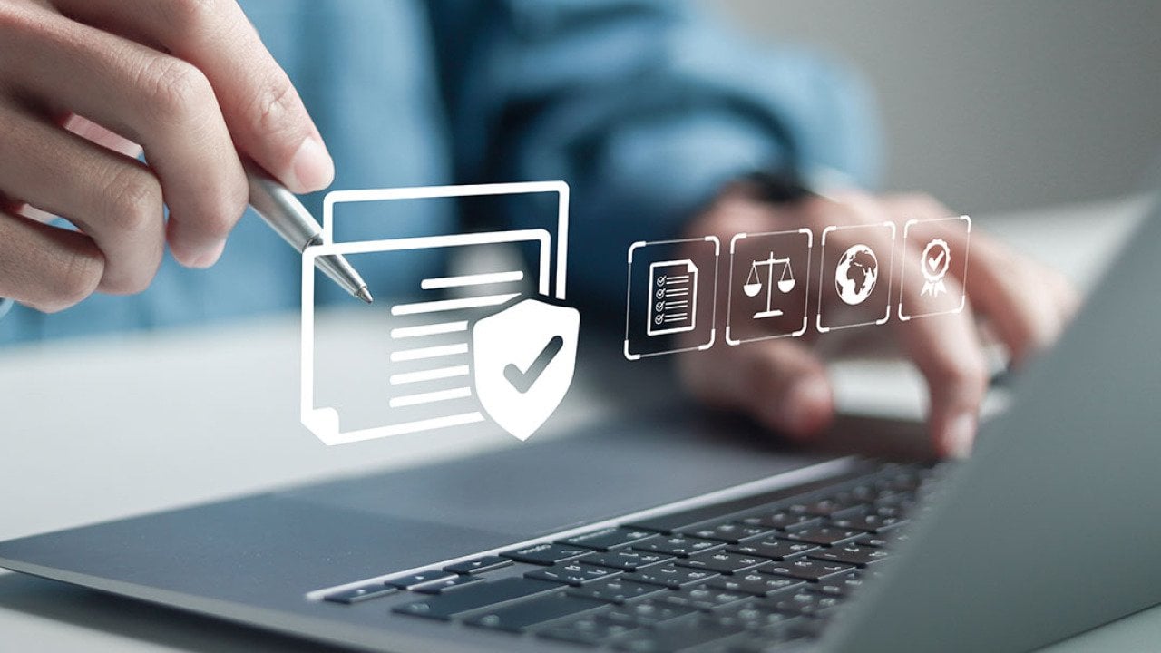 Businessman using a laptop illustrated with compliance software graphics.