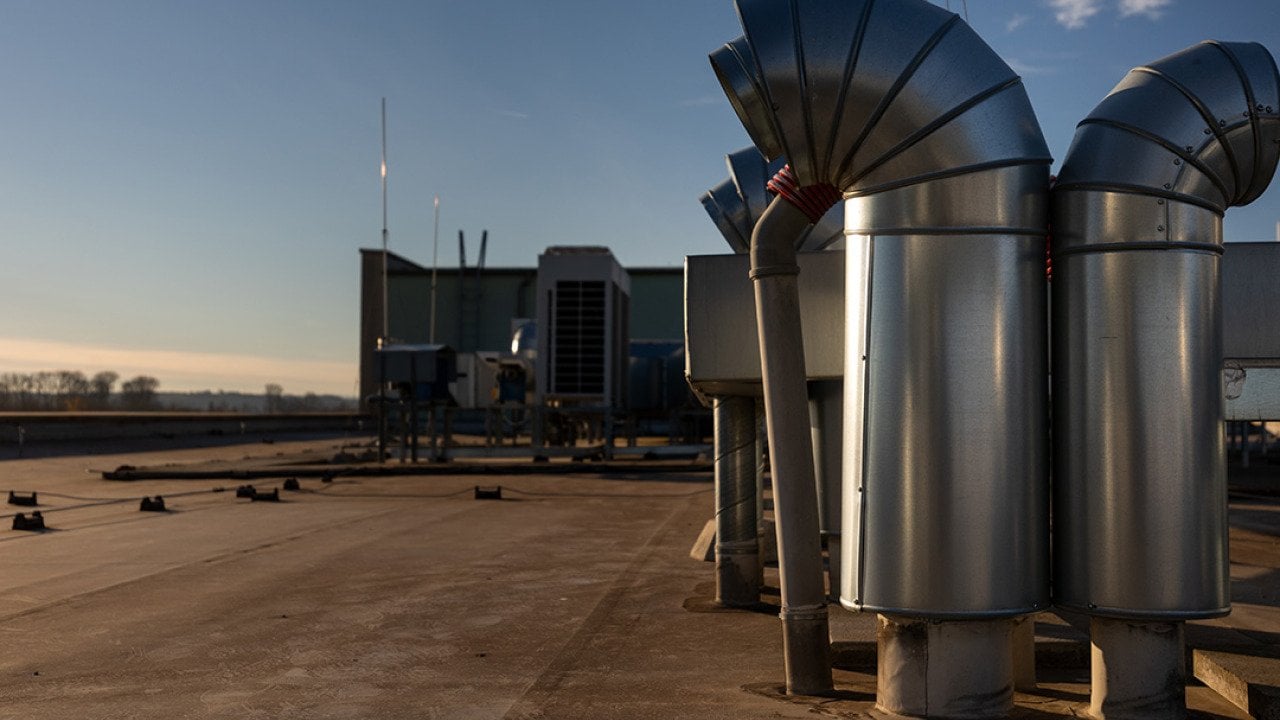 External air conditioning units and ventilation system installed on an industrial building's roof.