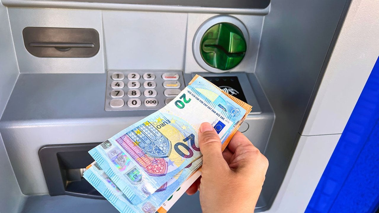 Person withdrawing Euros from an ATM.
