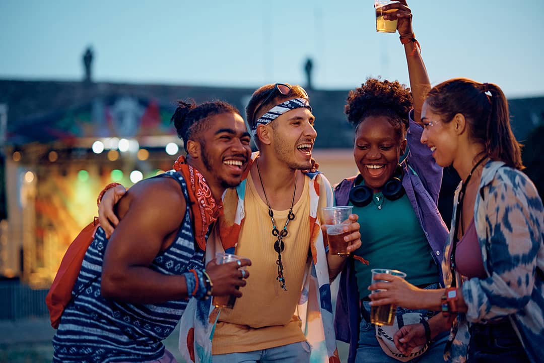 Friends enjoying and vibing to outdoors music during a summer music festival.
