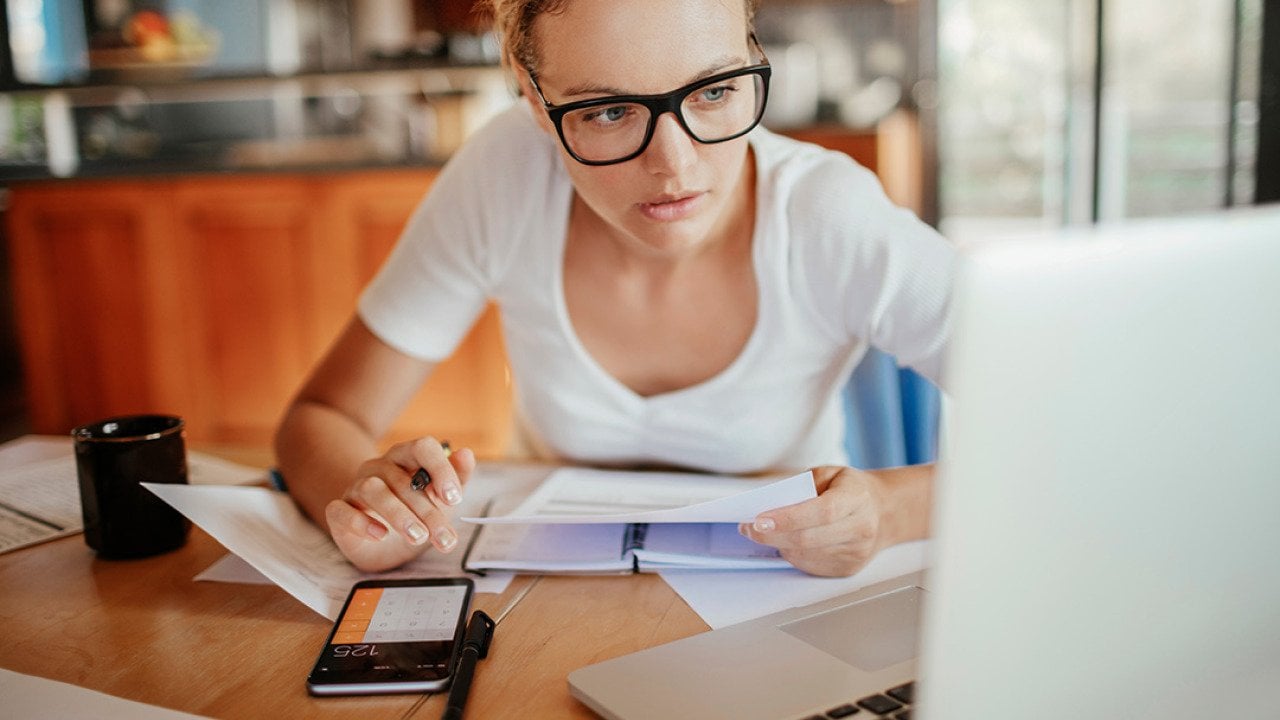 A young adult reviewing her property's documents from her laptop at home.