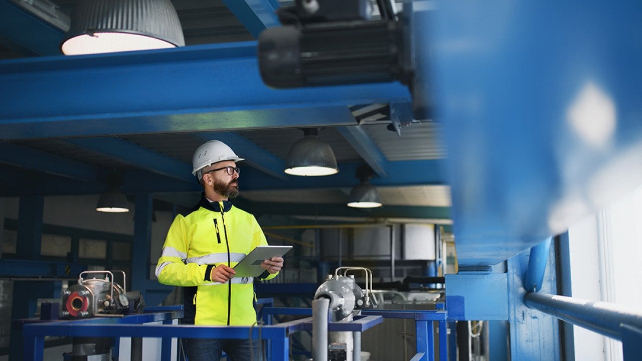 An engineer checking pipes inside an industrial factory.