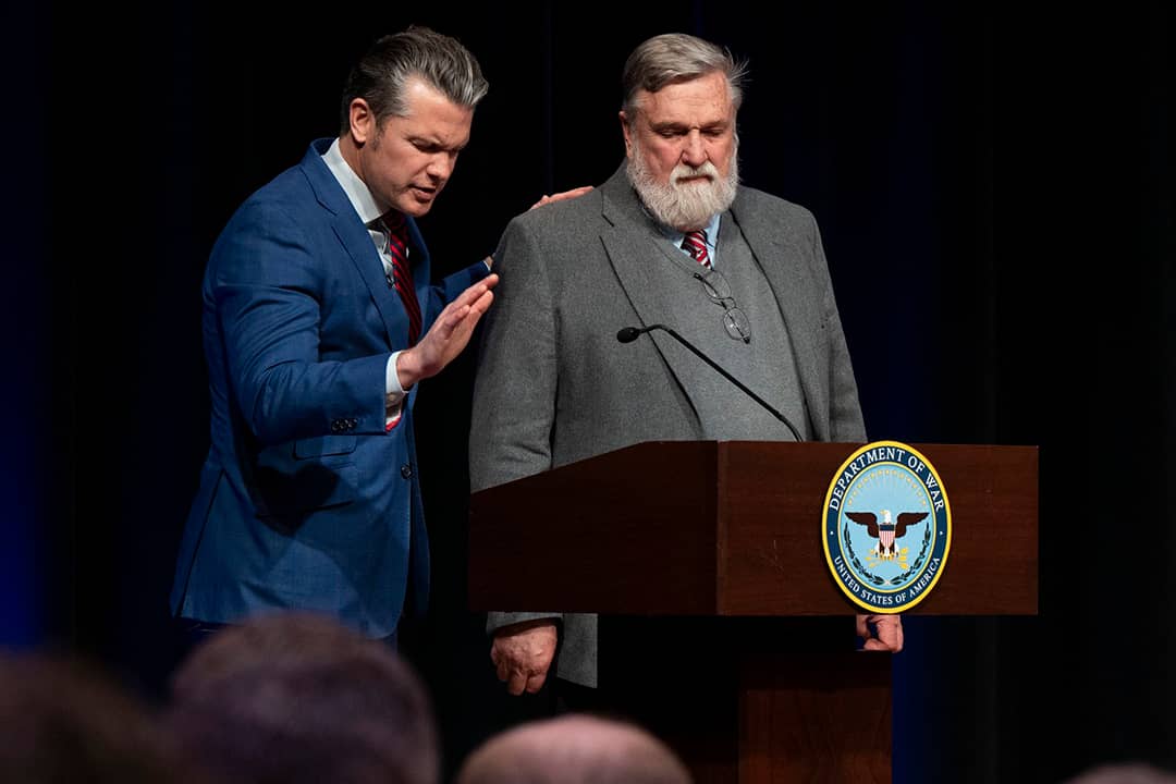 Pete Hegseth and Douglas Wilson stand at a podium during a Pentagon prayer service in February 2026.