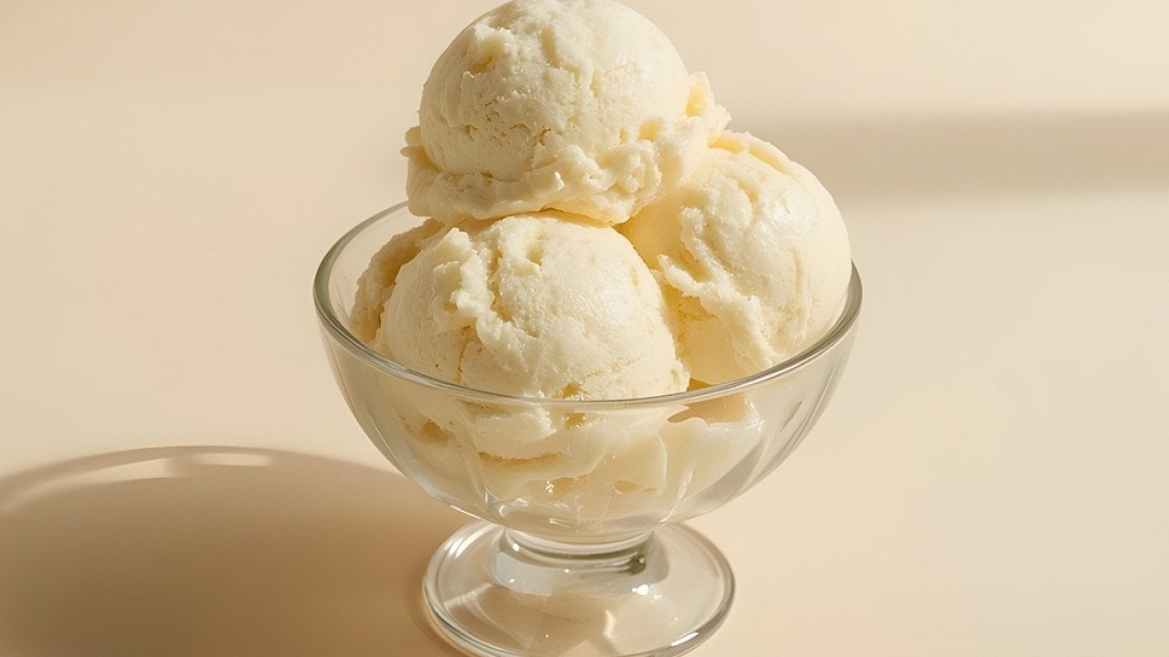 Premium vanilla ice cream scoops placed in a glass bowl. 