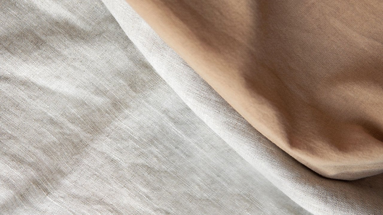 Folded linen cloths spread in a textured background.