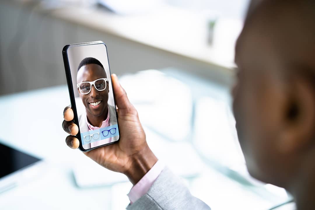 A person checking on virtual eyeglasses from an optical shop's (augmented reality) AR application online.