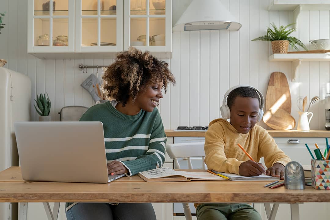 A mother checking his son's progress on a school homework while working at home.