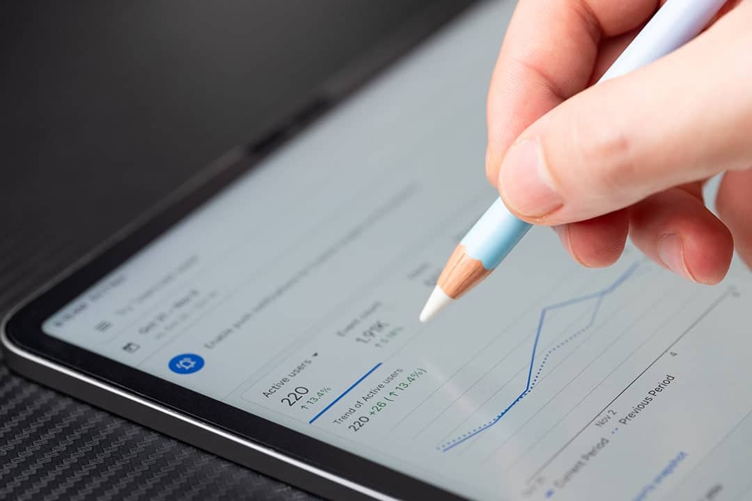 Person navigating Google Ads analytics dashboard on a tablet.