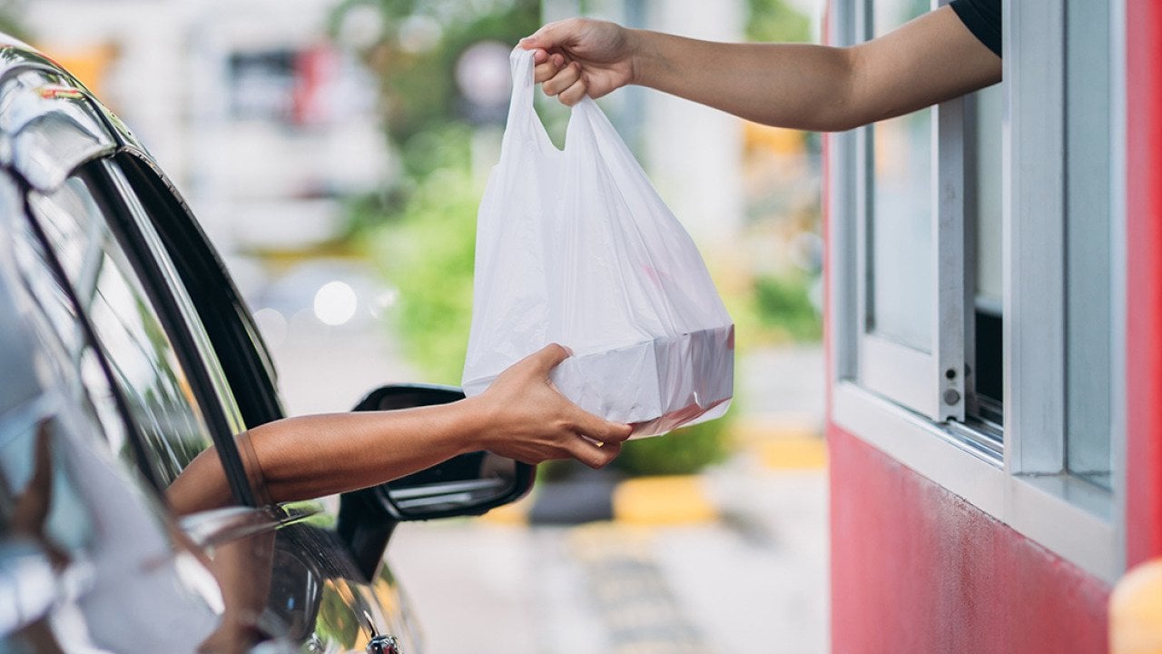 Person receiving their takeaway order at the drive thru.