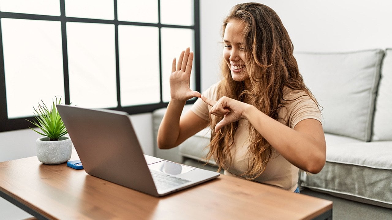 A person communicating through sign language during a Zoom video call.