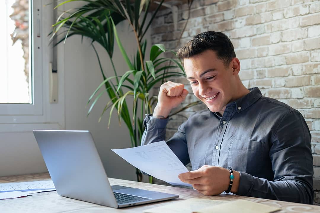 An excited businessman reading news from a letter.