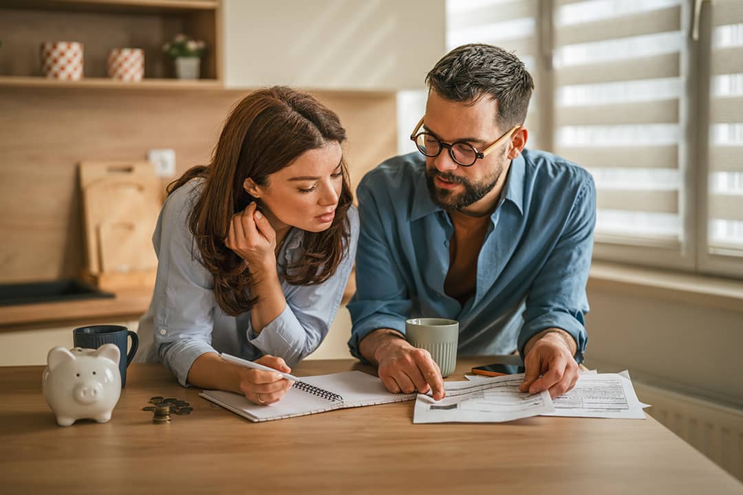A couple reviewing finances in their home kitchen.