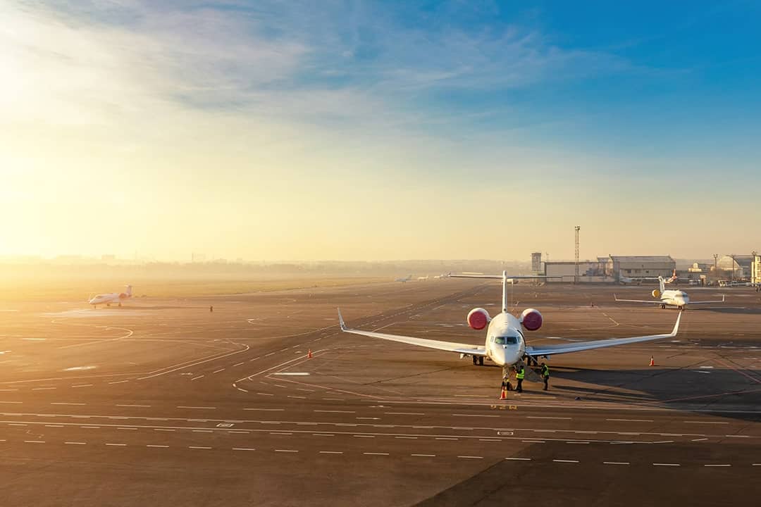 A private jet getting ready for a departure with a scenic sunset view in the background.