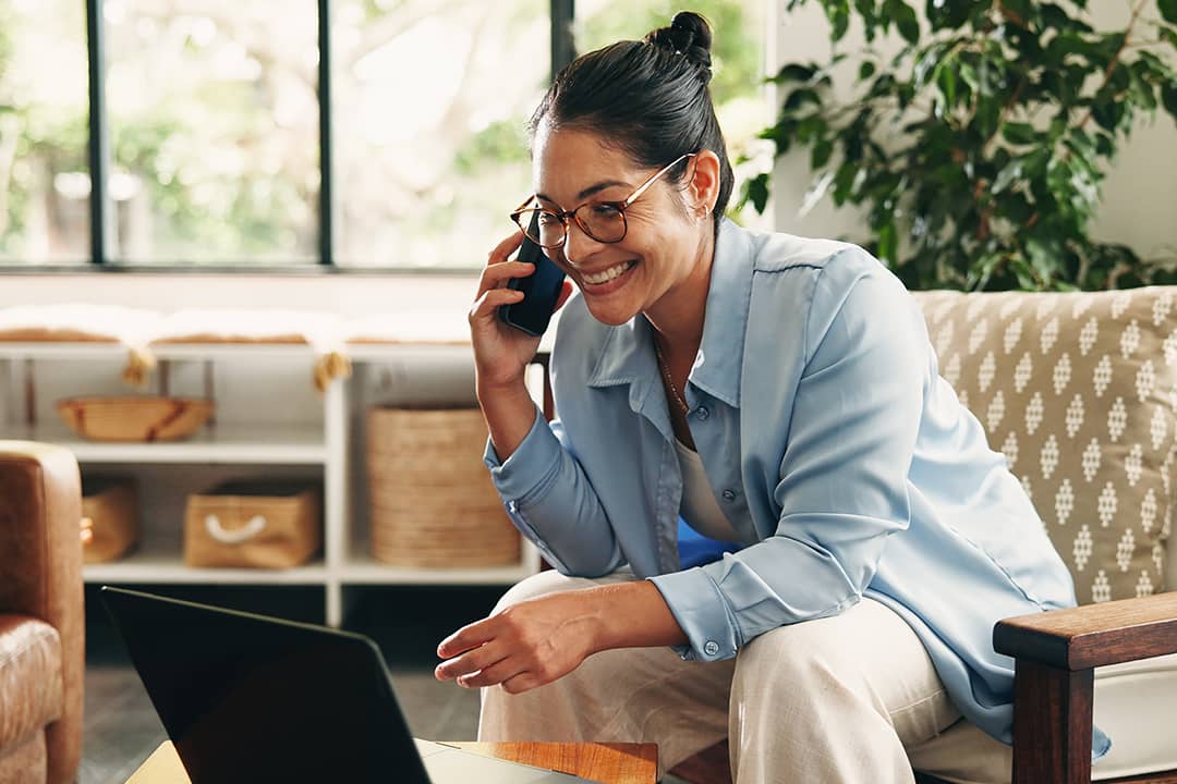 A business manager taking a phone call while working remotely at home.