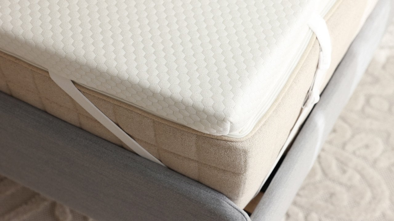A grey bed with a brand new memory foam mattress.