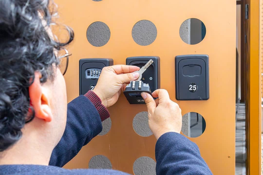 Person accessing key storage boxes.