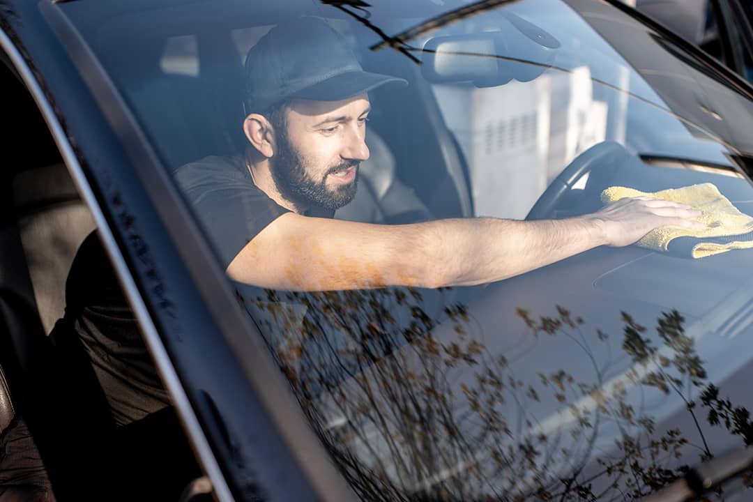 Man cleaning the interior of a car.
