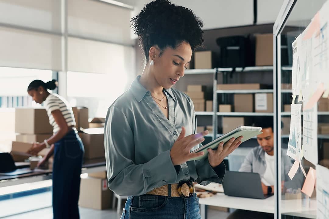 A female employee at a logistics team checking on orders.