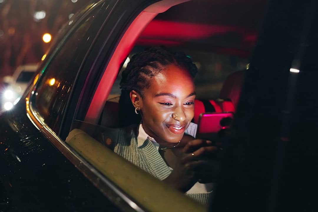 A person happily looking to a message notification from her smartphone.