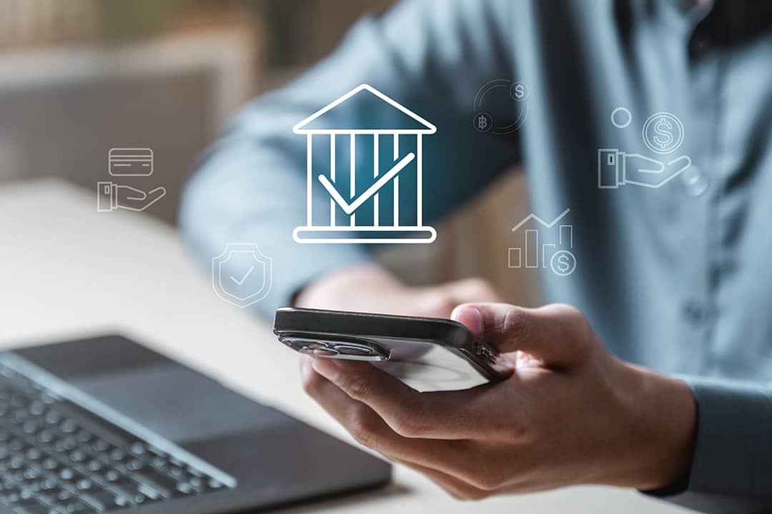 Person using a laptop and phone to view their bank account