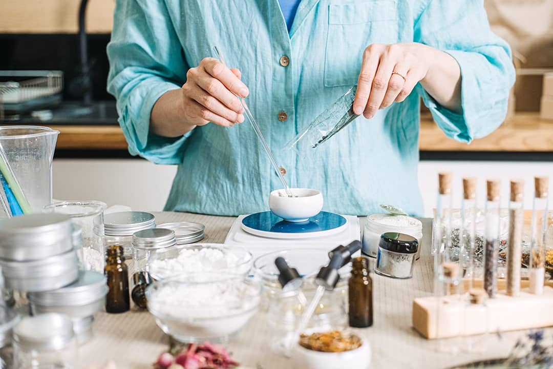 Person creating skincare mixtures at home using organic ingredients.