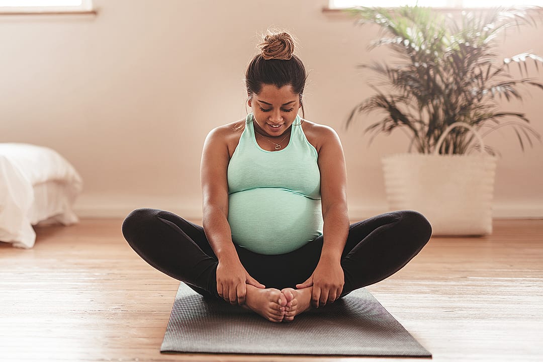 A pregnant woman doing yoga at home