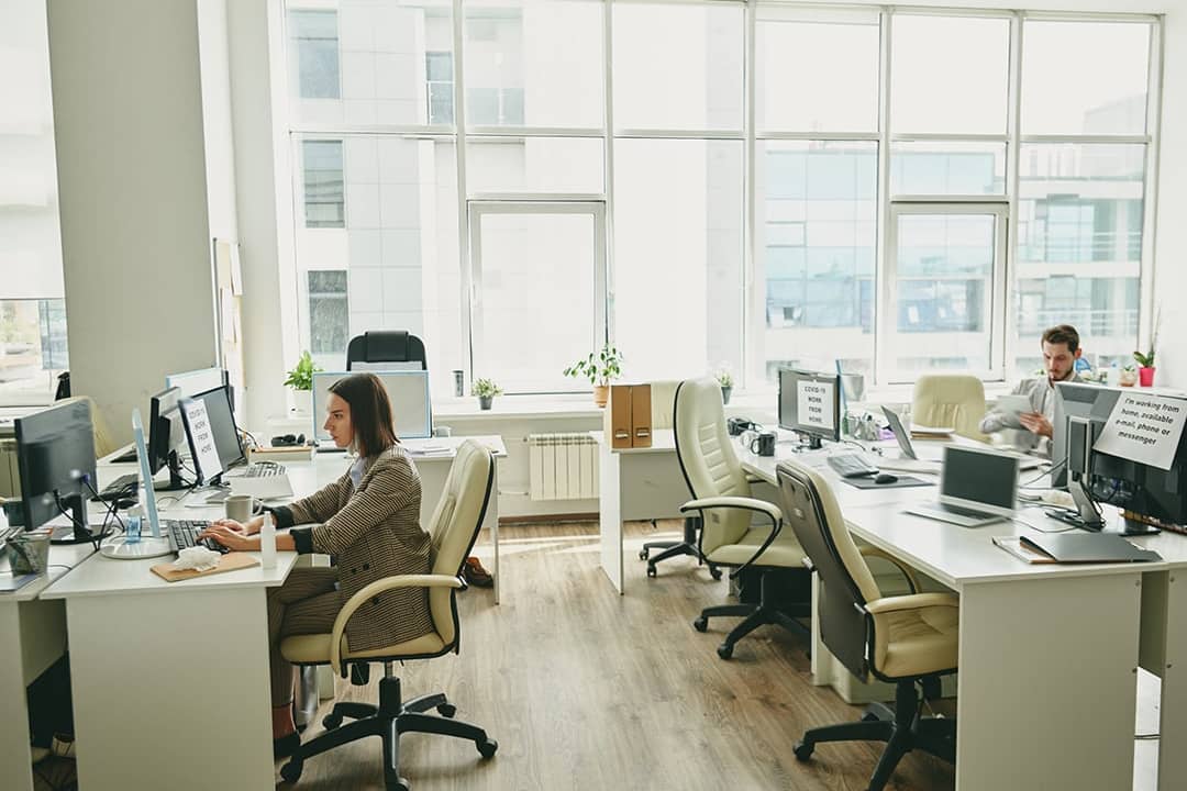 Employees sitting in a half-empty office.