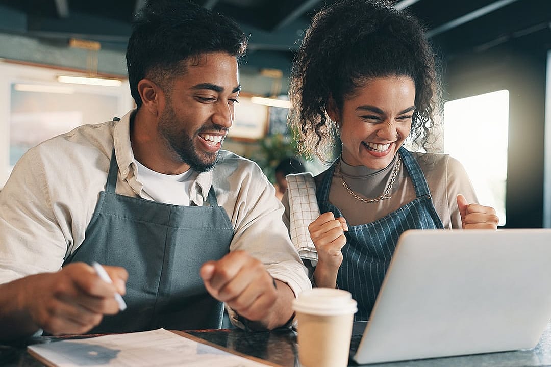 A team of small business owners happily reviewing business performance.