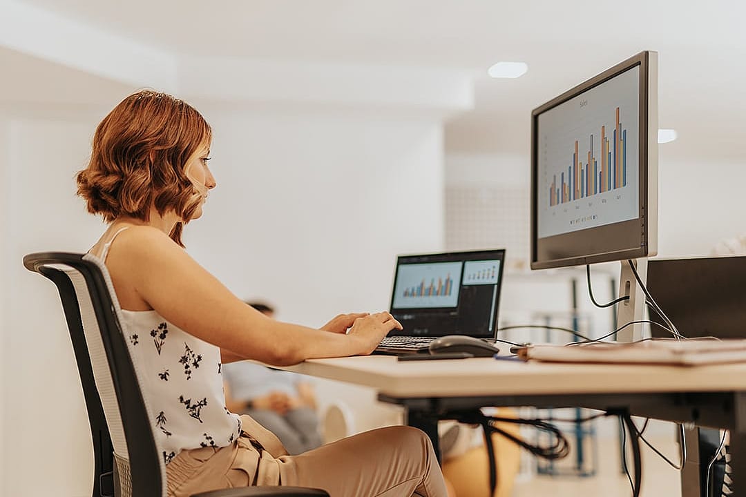 A data analyst reviewing data graphs and tools for a business sales dashboard.