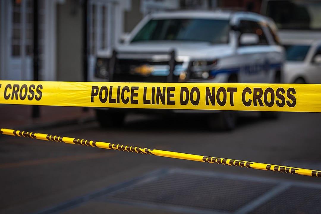 A 'Police Line Do Not Cross' tape at an entrance of a crime scene.