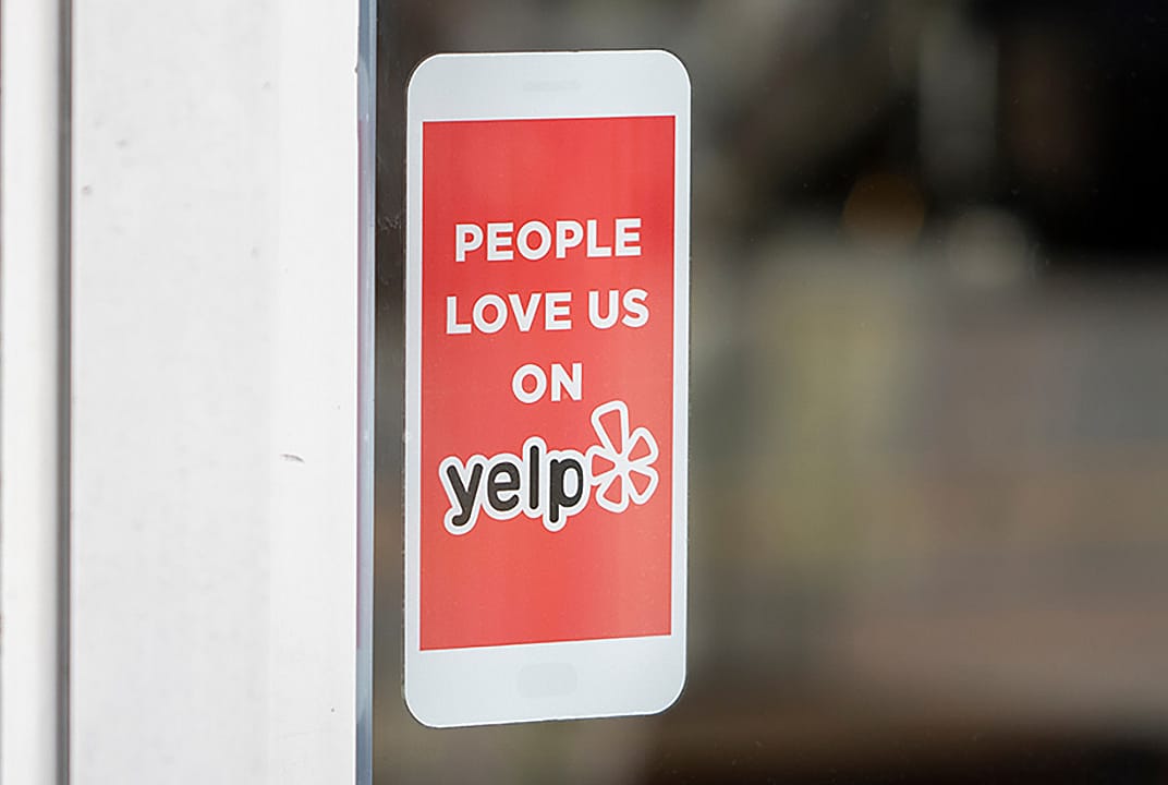 A 'People love us on Yelp' sticker at the entrance of a restaurant.