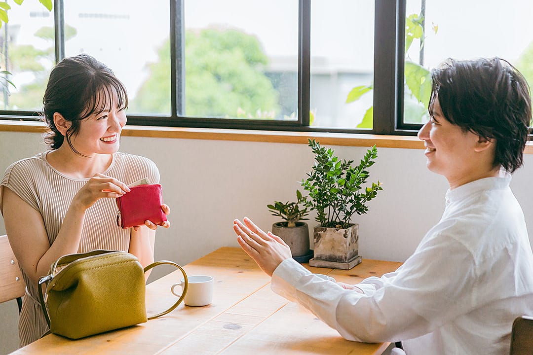 A young couple on a date where the woman gestures to offer payment.