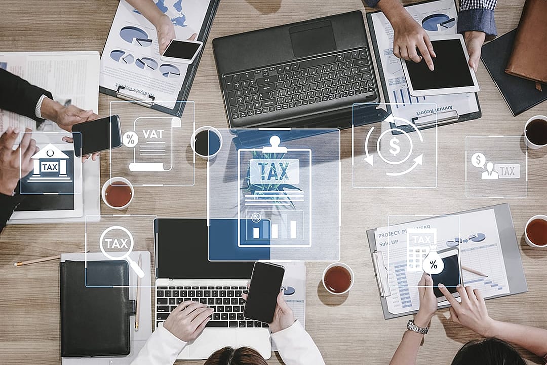 A conceptual graphic of a business team working around finance and tax compliance systems.