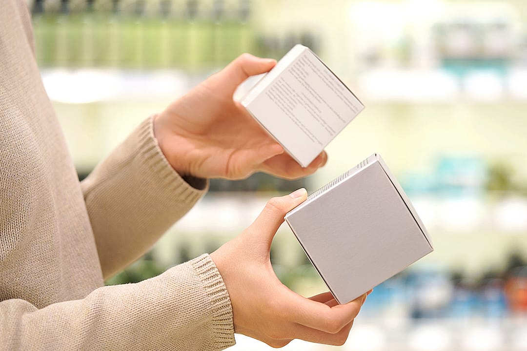 Person shopping for skincare items reading ingredient labels.