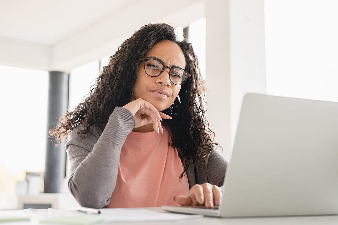 A person reviewing her monthly budget, expenses, and other personal finances from a laptop.