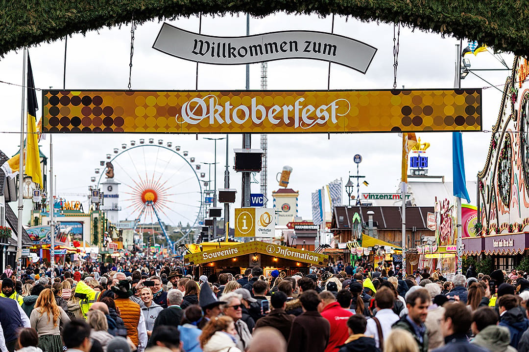 Numerous visitors walk through the gate from the main entrance to the 190th Oktoberfest on the Theresienwiese in Munich, Germany.