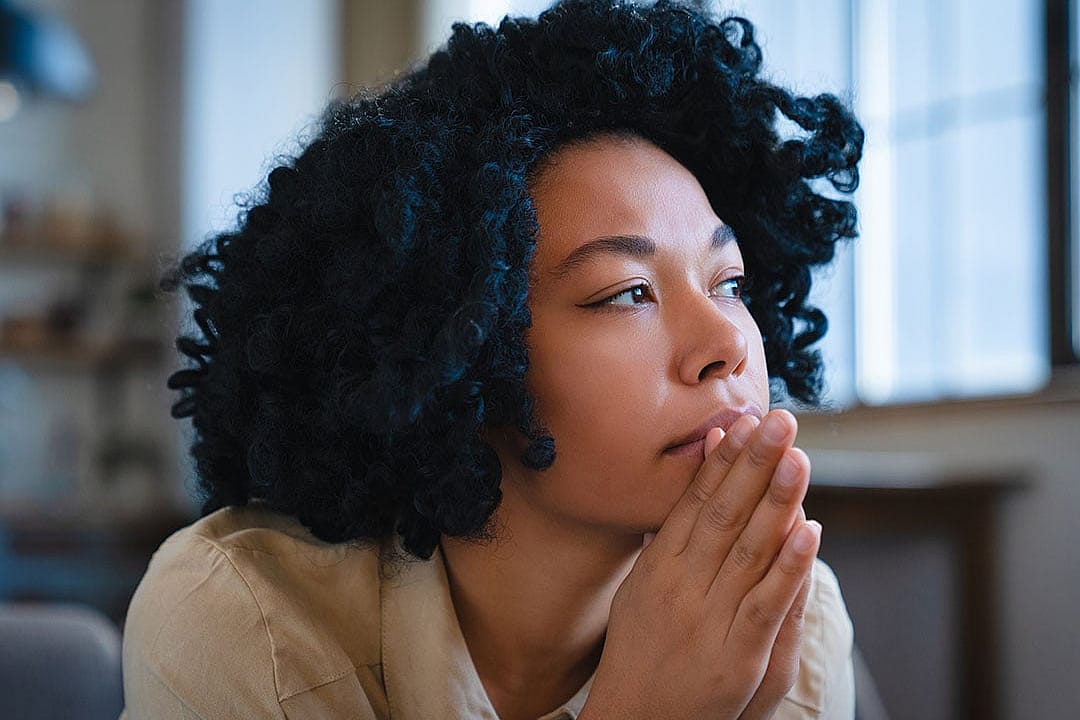A pensive young woman looking into the distance.
