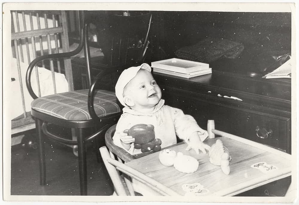 Vintage photo of a baby sitting with toys. 