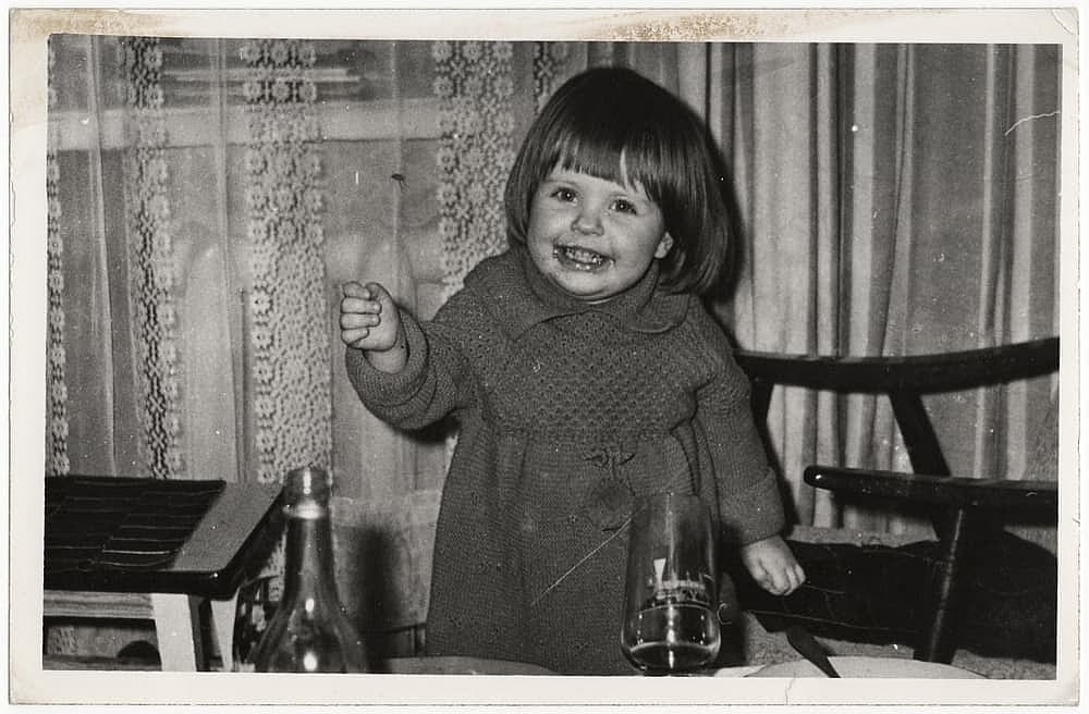 Vintage candid photo of a cute little girl laughing.