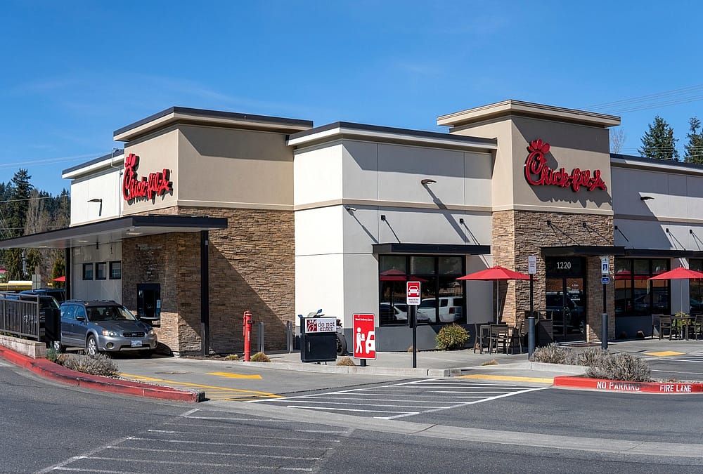 Entrance and shopwindow of Chick fil a restaurant at sunny day.