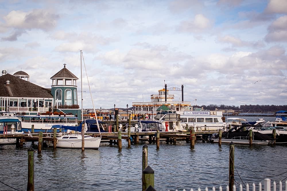 Alexandria, Virginia, US - December 29, 2024: historic buildings, marina  and boardwalk along the Potomac River waterfront, Old Town Alexandria, Virginia. Building and docks on the Potomac River