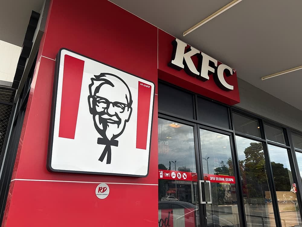  KFC restaurant front with Colonel Sanders sign and modern red facade design.