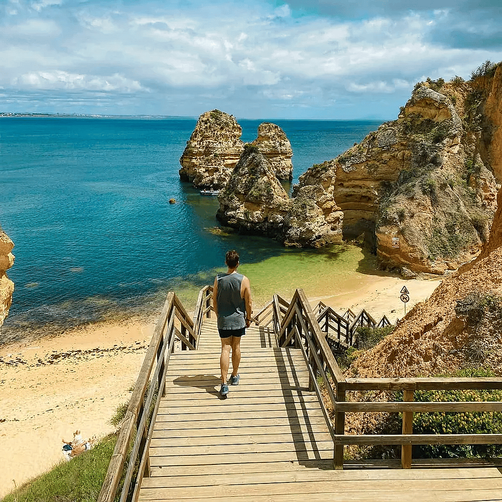 Golden cliffs and rock formations along a picturesque beach in Algarve, Portugal.