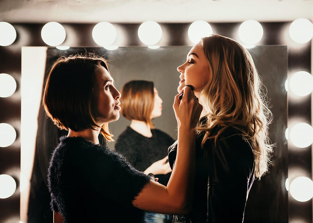 A makeup artist gets a performer ready.